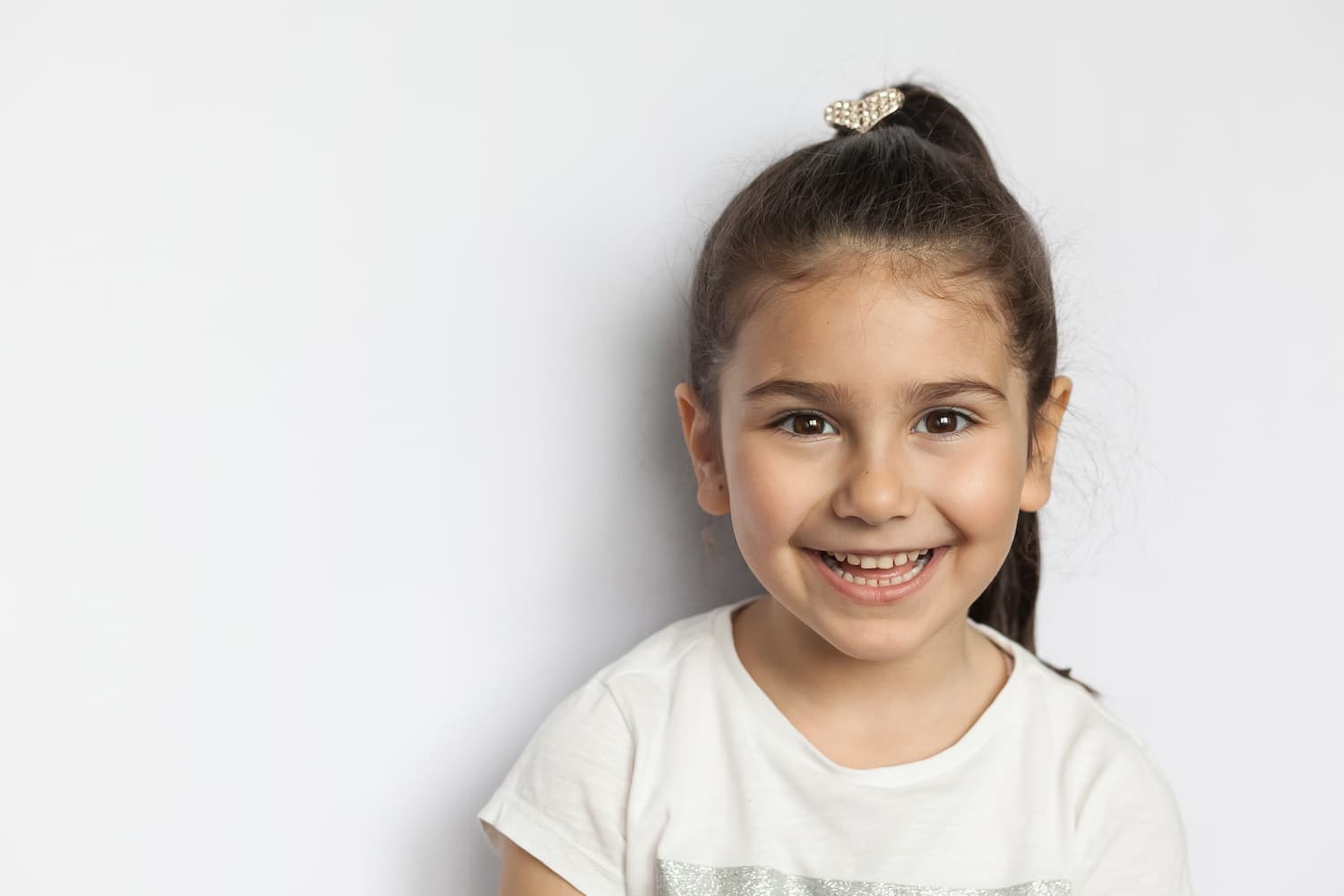 A child smiling whilst looking into the camera