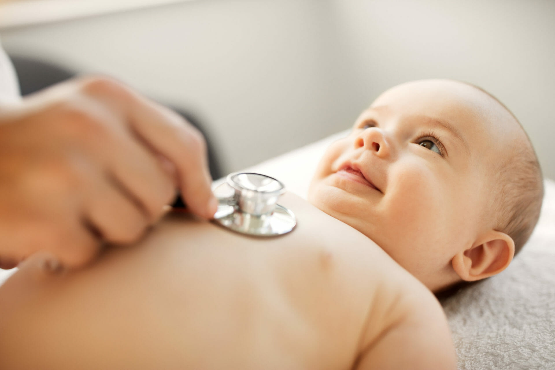 doctor with stethoscope listening to a baby