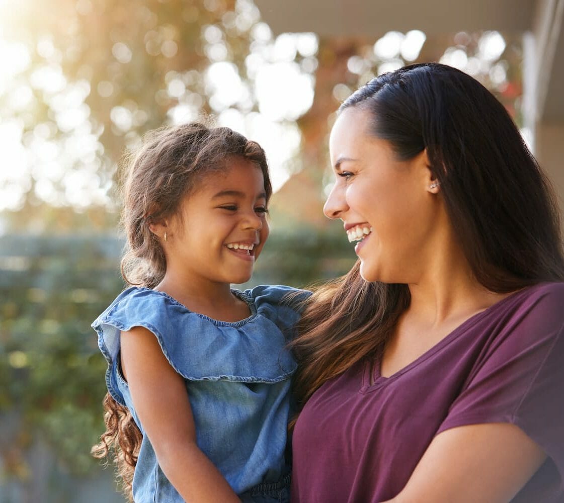 A mother holding her child and laughing