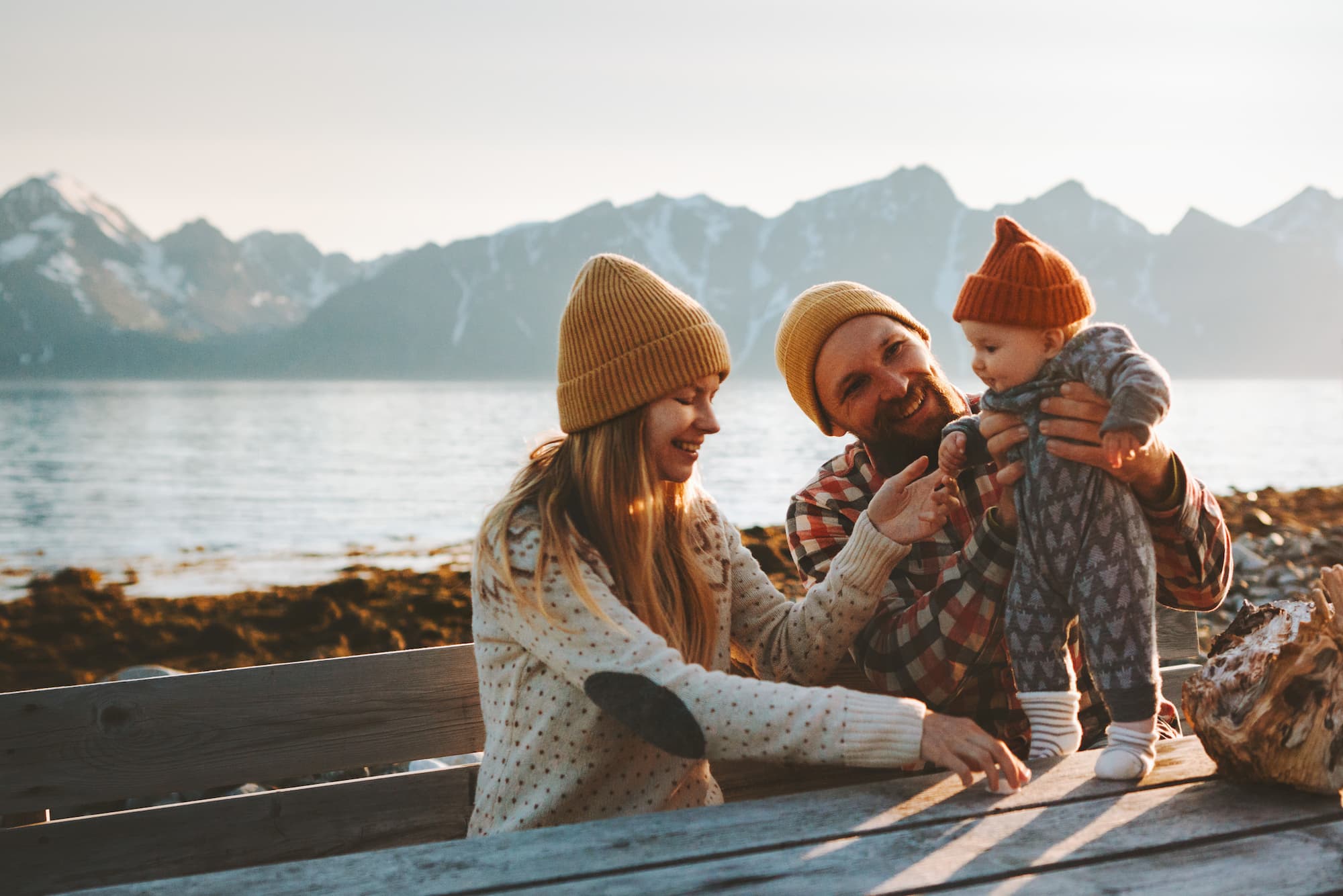 A family at a serene lake playing with their baby