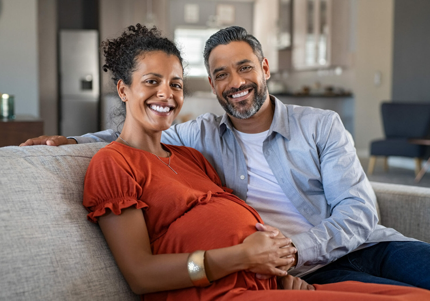 pregnant woman sat on sofa with husband