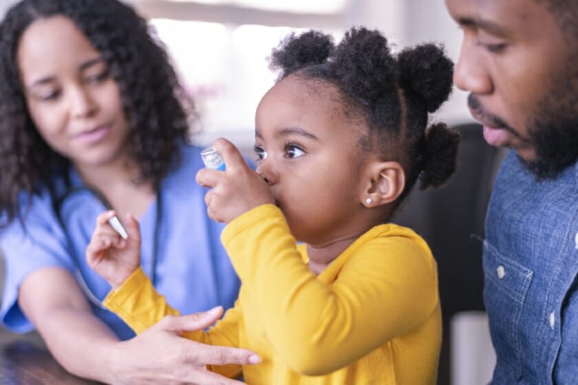 A child using a blue ventolin inhaler