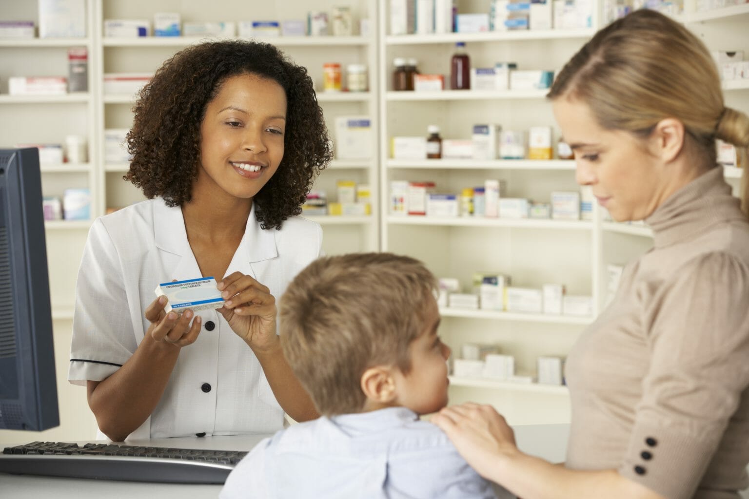A mother and son purchasing medication from a pharmacy
